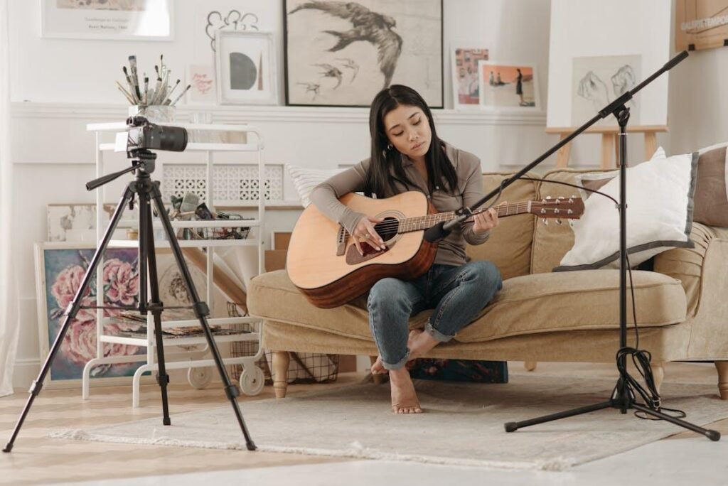 A woman recording herself playing the guitar