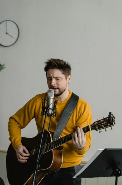 This image shows a man singing and playing the guitar.