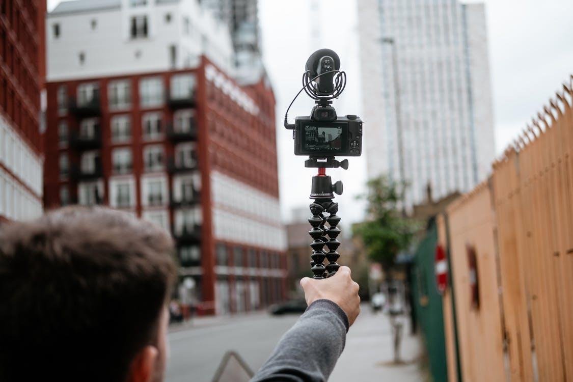 A person recording buildings using a camera