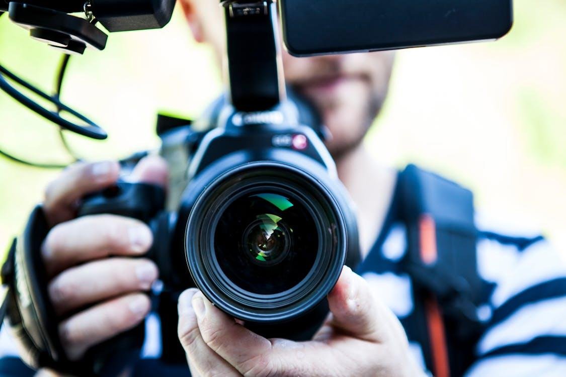 A close-up of a person holding a DSLR camera