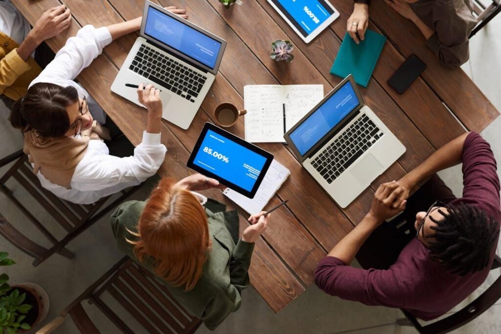 A group of people at a table with laptops