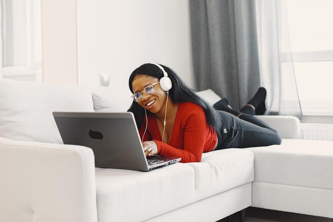 A person using a laptop and wearing headphones