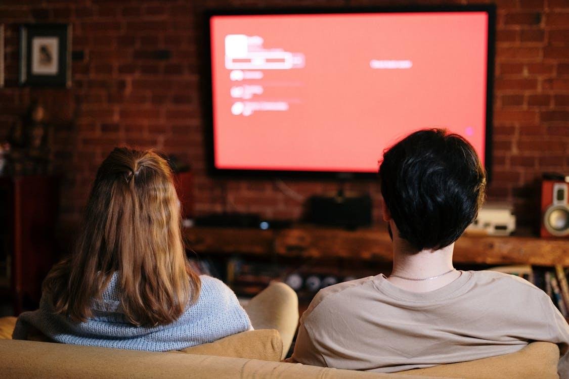 Two people watching a television