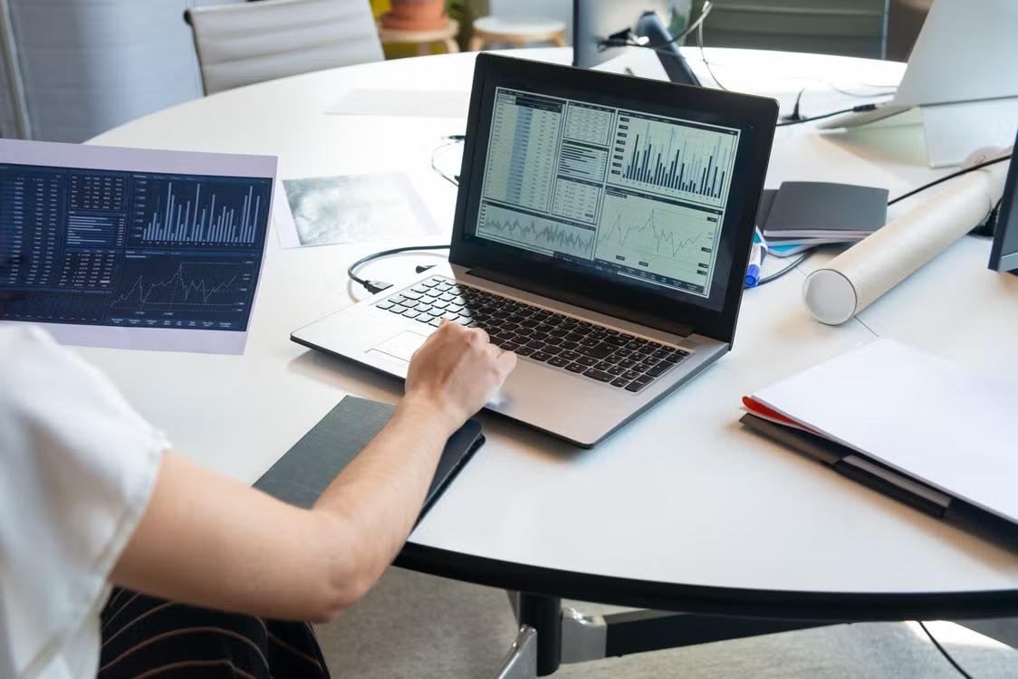 A laptop and papers with graphs